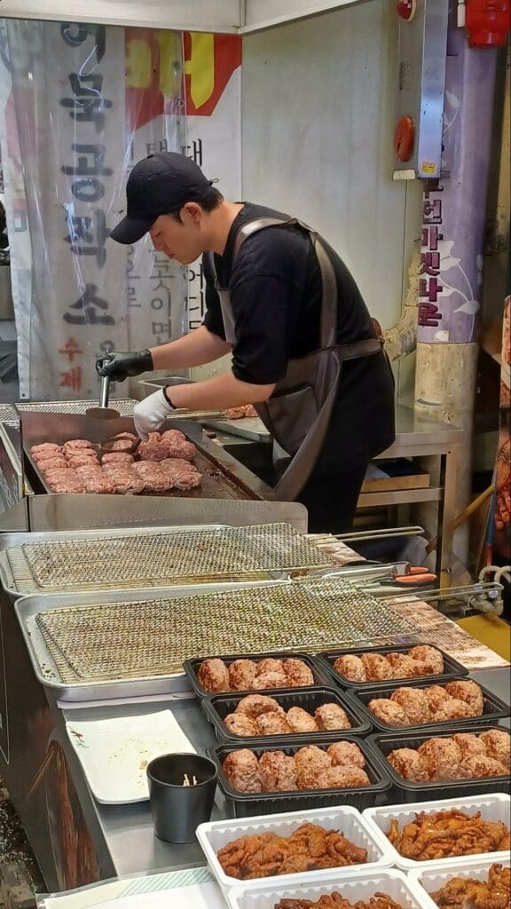 韓國特色小吃 正在翻漢堡肉的老闆